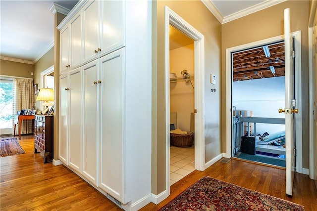 corridor with ornamental molding and hardwood / wood-style floors