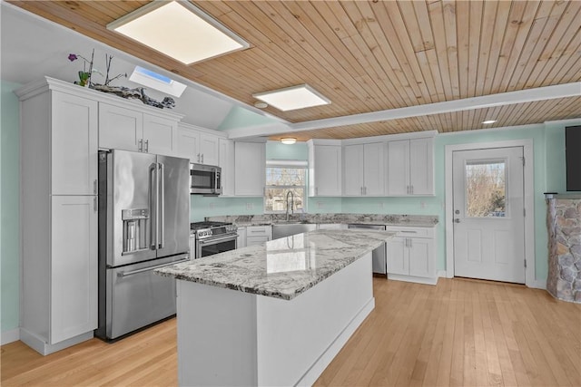 kitchen with appliances with stainless steel finishes, a sink, white cabinets, and a healthy amount of sunlight