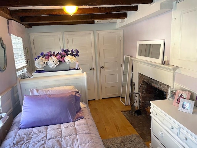 bedroom featuring beam ceiling and light hardwood / wood-style floors