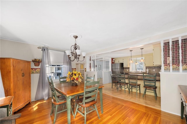 dining room featuring light wood-type flooring and a chandelier