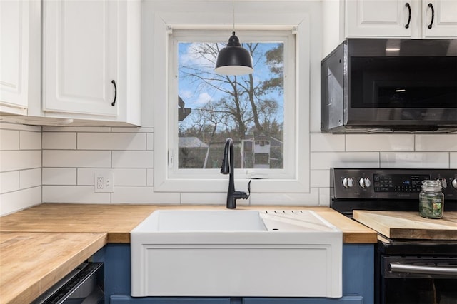 kitchen with electric range, white cabinets, hanging light fixtures, and wooden counters