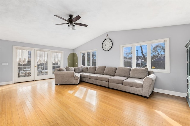 living room featuring light hardwood / wood-style floors, plenty of natural light, and lofted ceiling