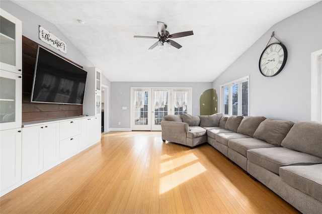 living room featuring ceiling fan, light wood-type flooring, vaulted ceiling, and french doors