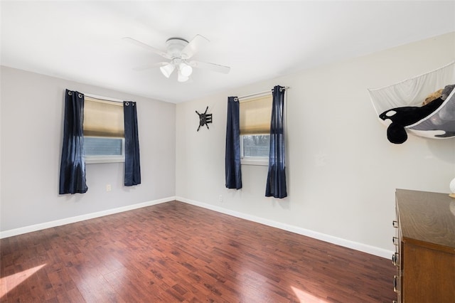 empty room with dark wood-type flooring and ceiling fan