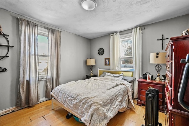 bedroom with light hardwood / wood-style flooring and a textured ceiling