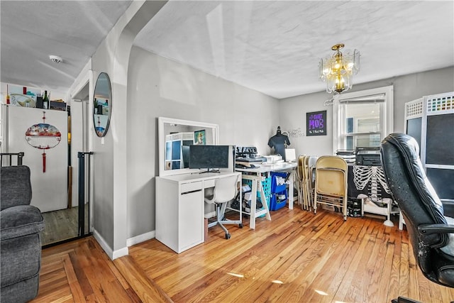 office area with light wood-type flooring and a notable chandelier