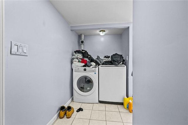 clothes washing area featuring light tile patterned flooring and separate washer and dryer