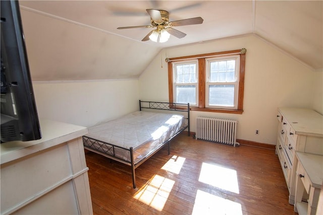 unfurnished bedroom with ceiling fan, hardwood / wood-style flooring, radiator heating unit, and lofted ceiling