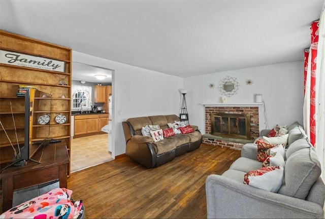 living room featuring a brick fireplace and dark hardwood / wood-style floors