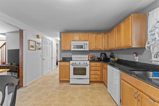 kitchen with sink, white appliances, and dark stone counters