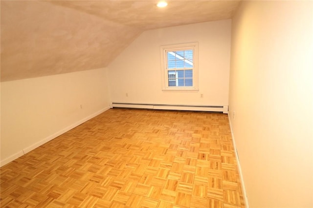 bonus room featuring lofted ceiling, a baseboard heating unit, and light parquet flooring