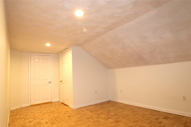 additional living space with vaulted ceiling and light parquet floors