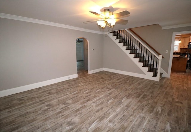 unfurnished living room featuring ceiling fan, dark wood-type flooring, and ornamental molding