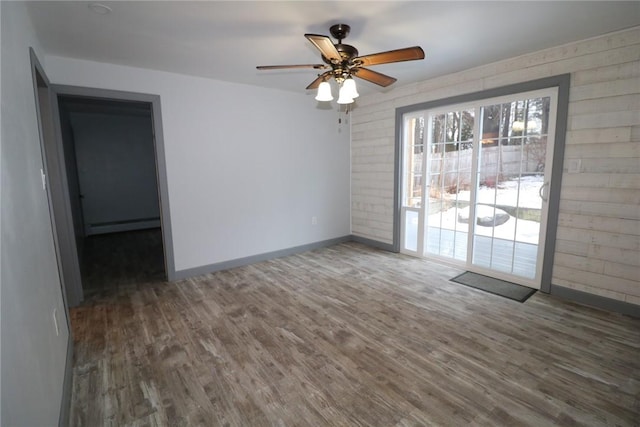 spare room featuring ceiling fan, dark hardwood / wood-style floors, and a baseboard radiator