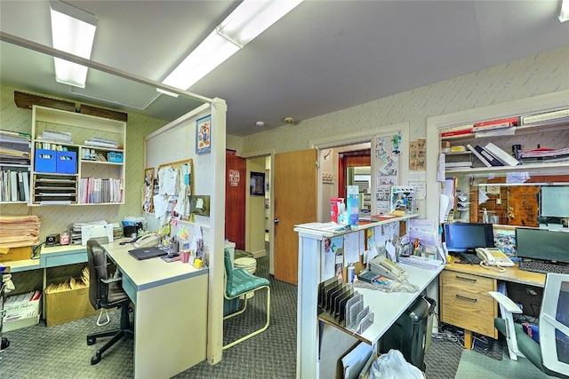 office area with dark carpet and a workshop area