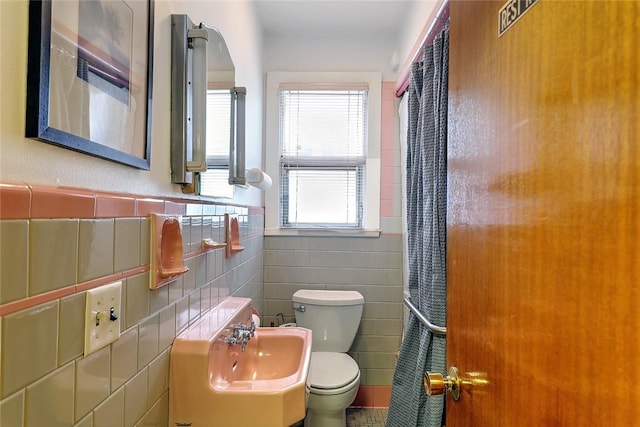 bathroom with tile walls, sink, and toilet