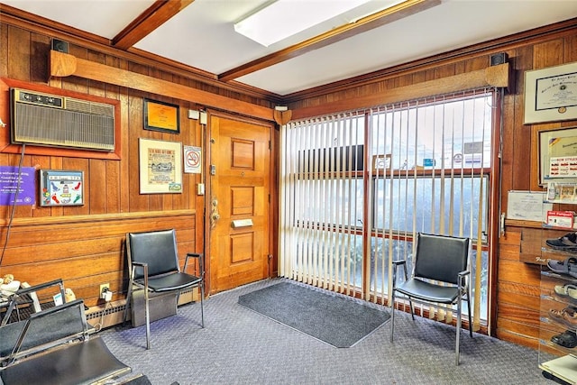 interior space with carpet floors, an AC wall unit, wooden walls, and beam ceiling