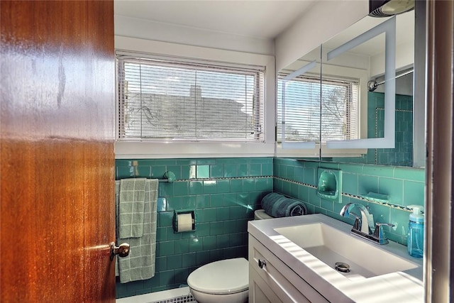 bathroom featuring tile walls, vanity, and toilet