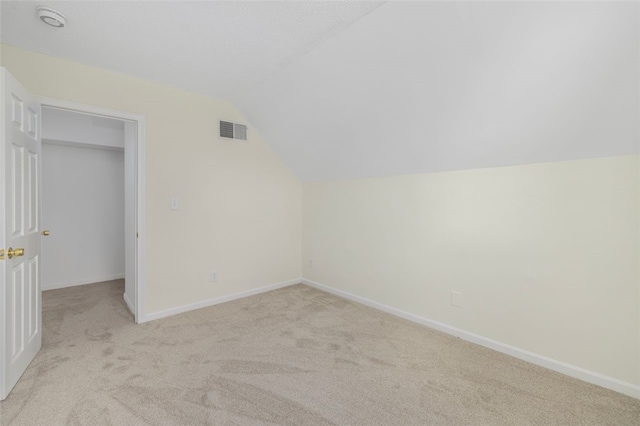 bonus room featuring vaulted ceiling and light carpet