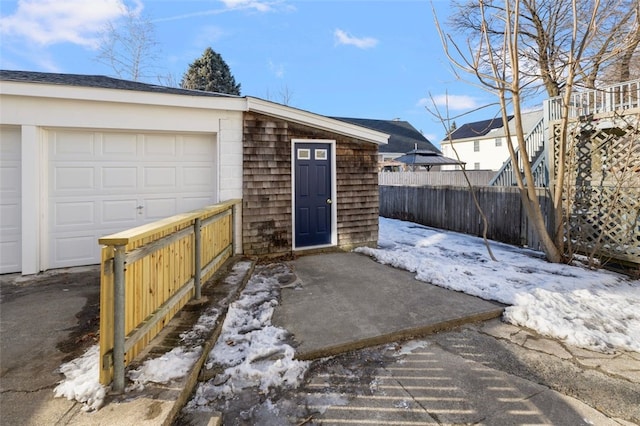 snow covered structure featuring a garage