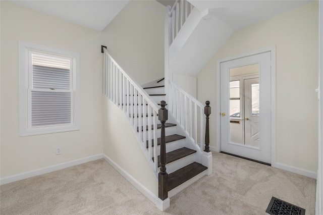 staircase featuring carpet