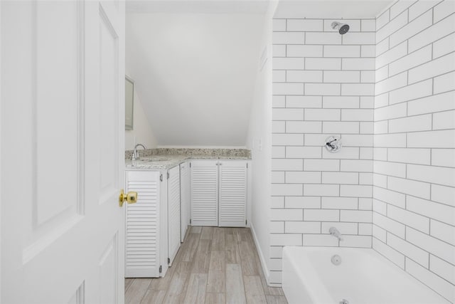 bathroom featuring tiled shower / bath combo, hardwood / wood-style flooring, and vanity