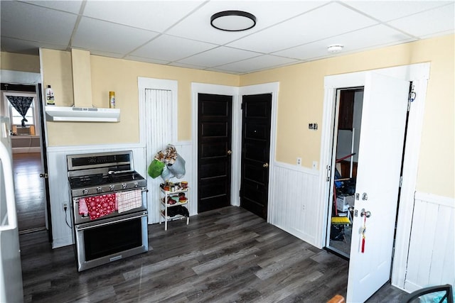 kitchen with dark hardwood / wood-style flooring, a wall mounted air conditioner, a paneled ceiling, and stainless steel range with gas cooktop