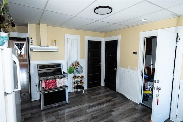 kitchen with white fridge, a paneled ceiling, and gas range