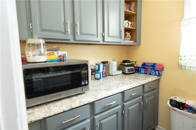 kitchen featuring gray cabinetry and light stone countertops