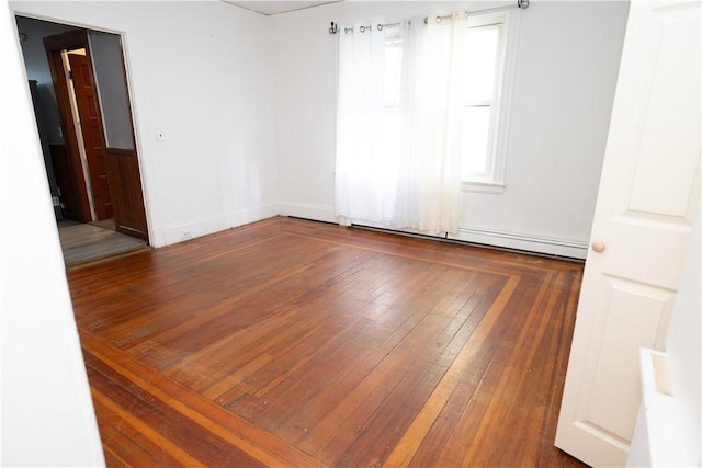 unfurnished room with dark hardwood / wood-style flooring and a baseboard heating unit