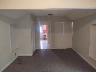 carpeted spare room with baseboards and vaulted ceiling