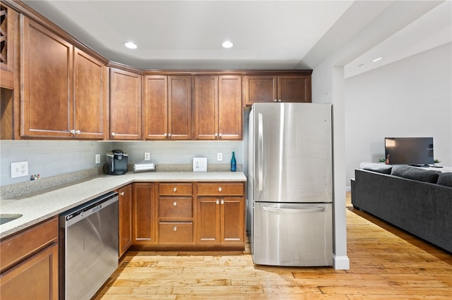 kitchen featuring light hardwood / wood-style floors, appliances with stainless steel finishes, and decorative backsplash