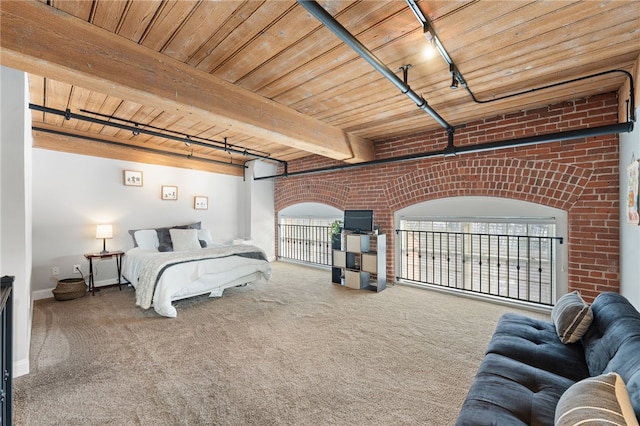 carpeted bedroom with multiple windows, beamed ceiling, wooden ceiling, and brick wall