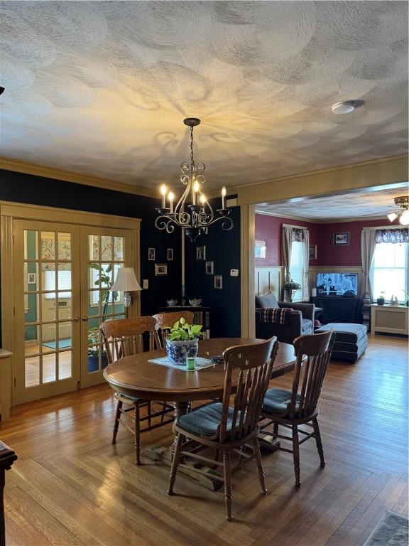 dining space featuring a textured ceiling, french doors, parquet flooring, and ornamental molding