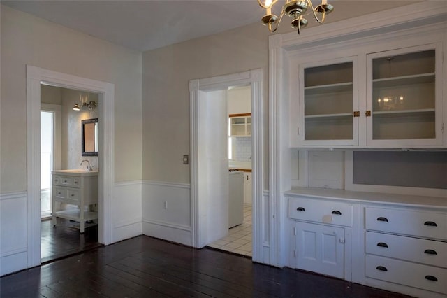 interior space featuring washer / clothes dryer, an inviting chandelier, and dark hardwood / wood-style flooring