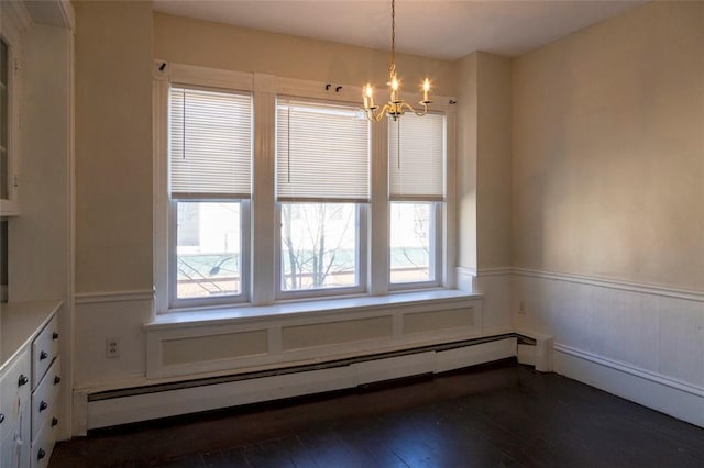 unfurnished dining area with dark wood-type flooring, a notable chandelier, and a baseboard radiator