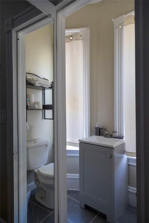 bathroom with vanity, tile patterned flooring, and toilet