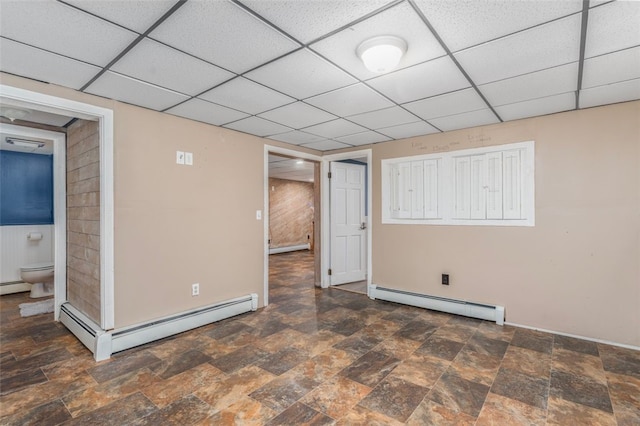 basement with baseboard heating and a drop ceiling