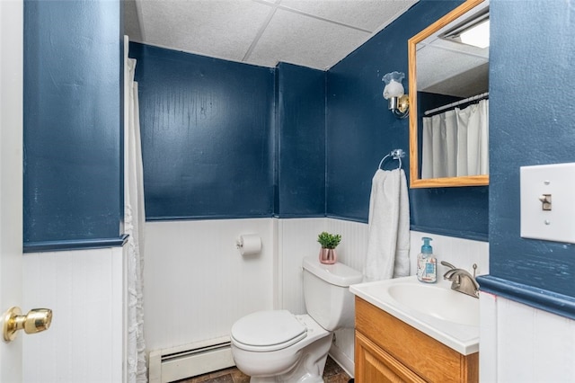 bathroom featuring a baseboard radiator, toilet, vanity, and a paneled ceiling