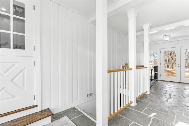 hall featuring decorative columns and french doors