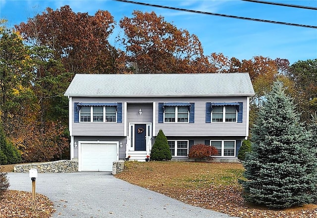 raised ranch featuring a front lawn and a garage