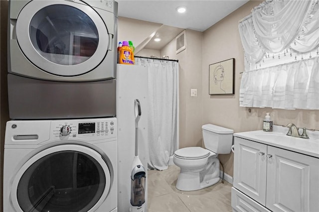 laundry area featuring light tile patterned floors, sink, and stacked washer / drying machine