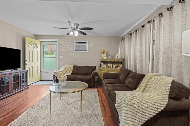 living room featuring ceiling fan, dark hardwood / wood-style floors, and a wall mounted air conditioner