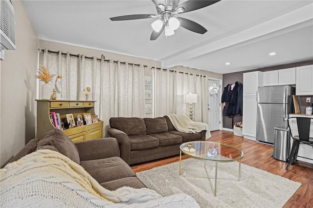 living room with ceiling fan, wood-type flooring, and beam ceiling