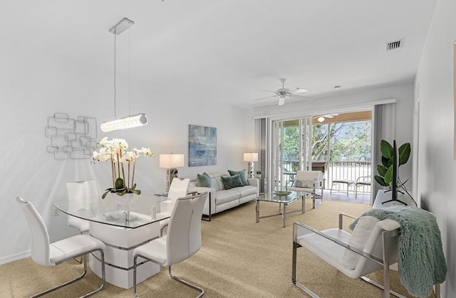 carpeted dining space featuring ceiling fan