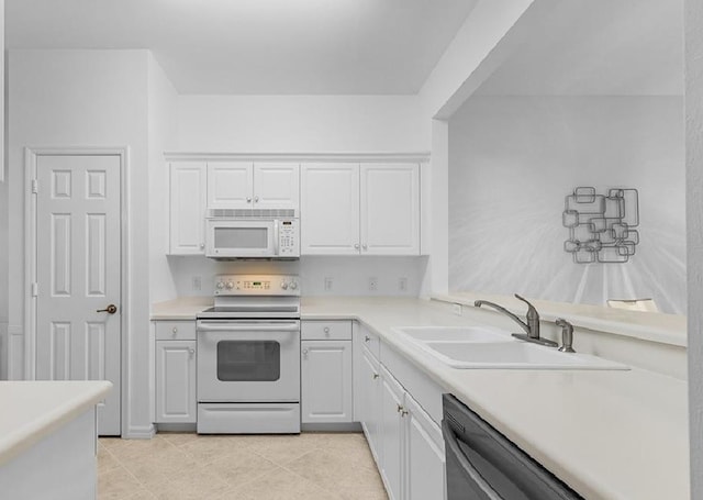 kitchen with sink, white appliances, white cabinets, and light tile patterned floors