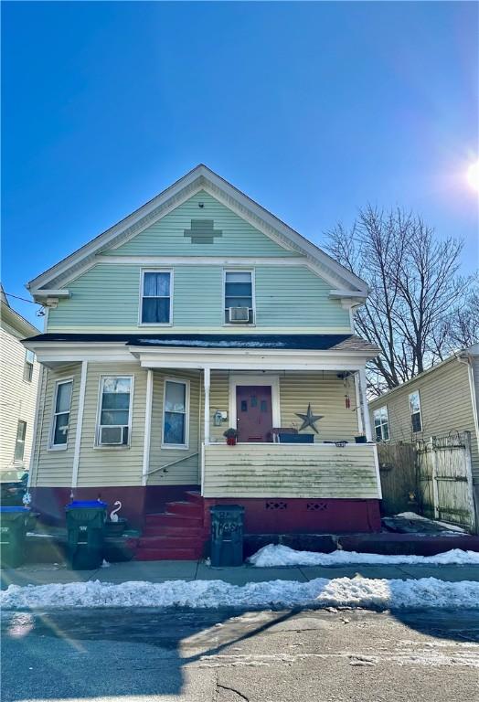 view of front of property with a porch and fence