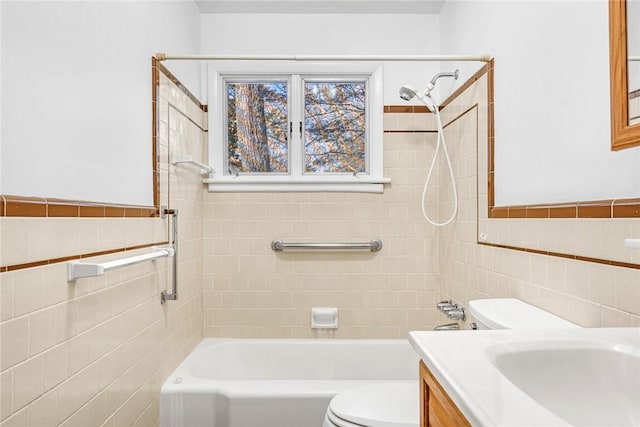 full bathroom with shower / washtub combination, a wainscoted wall, tile walls, toilet, and vanity