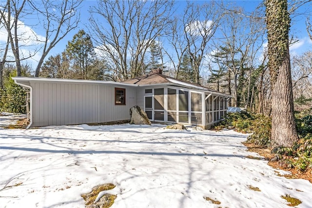 snow covered structure with a sunroom