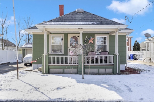 view of front of home featuring fence, a porch, and roof with shingles